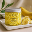 Jar of banana-scented whipped soap with sliced bananas on a tray
