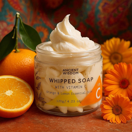 Jar of whipped soap with vitamin C, oranges, and flowers on a colorful background